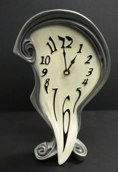 a white clock with black numbers on it's face is shown in this image