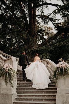 the bride and groom are walking down the stairs