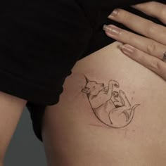 a woman's stomach with a cat tattoo on the side of her belly,