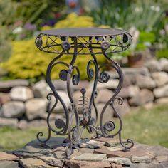 a small metal table sitting on top of a rock