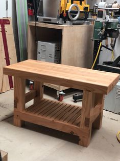 a wooden bench sitting in a garage next to tools