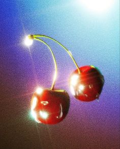 two cherries hanging from a yellow wire on a blue and purple background with the sun behind them