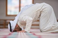 a man in a white suit is doing a handstand on the floor