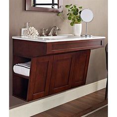 a bathroom sink with a mirror above it and a vase on the counter next to it