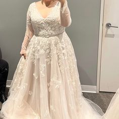 a woman in a wedding dress is taking a selfie with her cell phone while standing next to a mirror