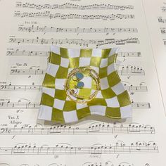 a green and white checkered flag sitting on top of sheet music