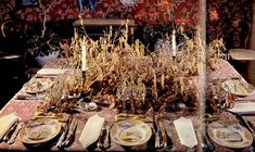 the table is set with plates, silverware and corn stalks for an elegant dinner