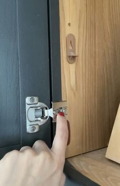 a person is opening the door with their finger and pressing the latch to open it