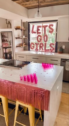 a table with pink candles on it in front of a sign that says let's go girls