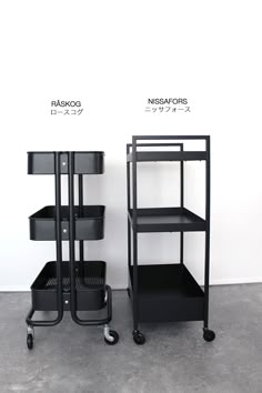 two black shelves sitting next to each other on wheels