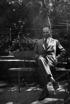 a man in a suit and tie sitting on a bench