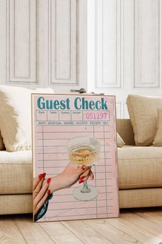 a guest check sign with a woman's hand holding a wine glass in front of it