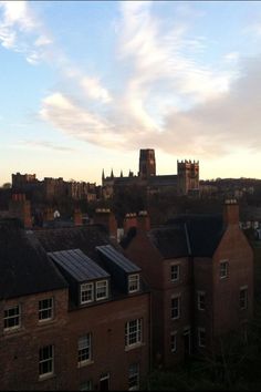 the view of some buildings and a church in the distance with a sky line behind them