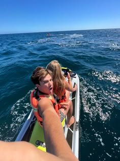 two people riding on the back of a boat in the ocean