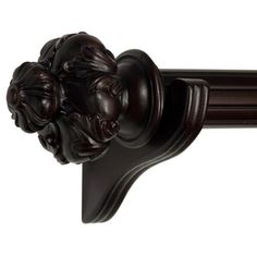 a close up of a curtain rod with two faces on it's end and an ornately carved handle