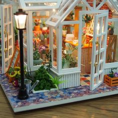 a doll house with flowers and plants inside