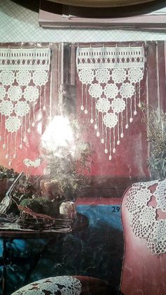 an image of a living room setting with crocheted curtains and lace on the window