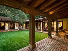 an outdoor patio with brick pavers and green grass