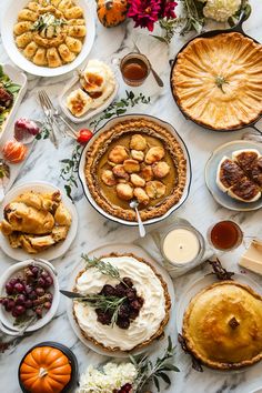 a table topped with pies and other food