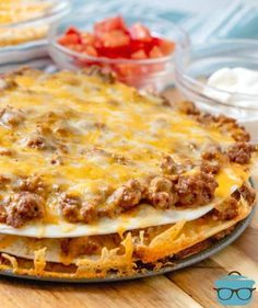 a cheesy pizza with cheese and ground beef on the top is ready to be eaten