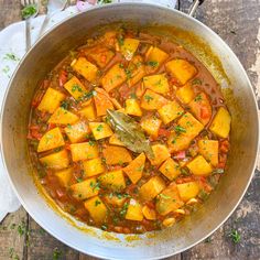 a pot filled with stew on top of a wooden table