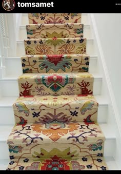 a carpeted stair case with colorful rugs on it