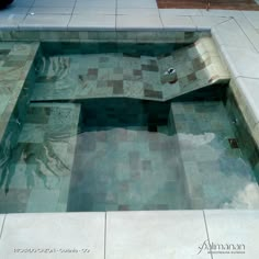 an empty swimming pool with tiled floor and walls