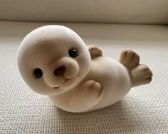 a small stuffed animal sitting on top of a white floor next to a window sill