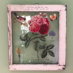 an old frame with flowers and butterflies in it on the wall next to a window