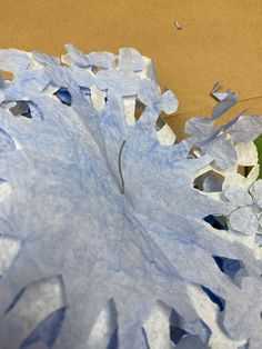 blue and white paper flowers sitting on top of a cardboard box