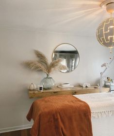 a bedroom with a bed, mirror and table