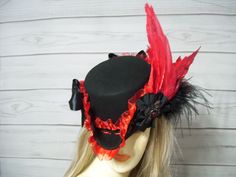 Black woolen felt ladies tricorn hat with red ruffled trim, black braid, black cocarde with jewel center, two red satin bows and two red dyed wings. Fabulous! The inside circumference is 22.5" with a built-in adjustable string. Just cinch and tie for a better fit. Perfect for Renaissance Fairs, Gasparilla Pirate event, 1800's Victorina events or even Halloween. I have many other hats in my shop if you would like to view them. International buyers are responsible for custom fees as it is not included in the shipping. Please Click on the shipping tab to calculate shipping so there are no surprises over shipping.    ALL SALES ARE FINAL!!! NO EXCHANGES! NO REFUNDS! ASK QUESTIONS AHEAD OF TIME AS ALL SALES ARE FINAL!!!   A lot of my hats are one-of-a-kind and If I do happen to offer the same ha Tricorn Hat, Pirate Hat, Steampunk Hat, Pirate Hats, Halloween Hats, Costume Hats, Black Braids, Beautiful Hats, Red Satin