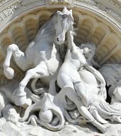 a white horse and rider statue in front of a building