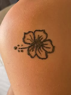 a close up of a person's back with a flower tattoo on it