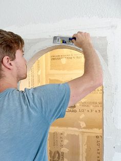 a man is painting the wall with white paint