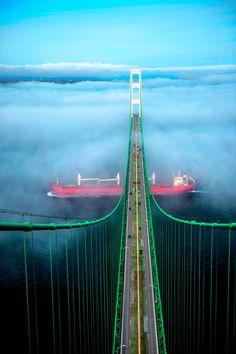 a long bridge that is surrounded by clouds