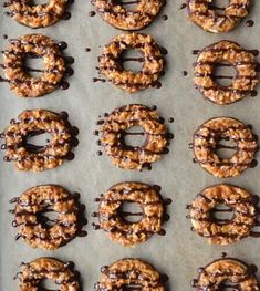 chocolate covered pretzels are lined up on a baking sheet and ready to be baked