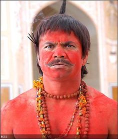 a man with red paint on his face and mustache