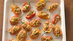 stuffed bell peppers with meat and vegetables on a white platter, ready to be eaten