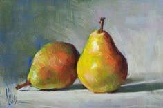 two pears are sitting on a white surface