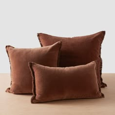 three brown pillows sitting on top of a wooden table