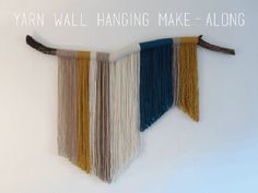 a wall hanging made out of yarn and wood sticks