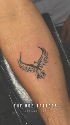 a tattoo on the arm of a man with a bird in it's beak