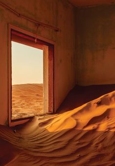 an open door in the middle of a desert with sand dunes behind it and a sky background