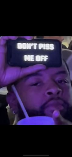 a man holding up a cell phone with the words don't piss me off on it