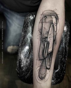 a person with a tattoo on their arm holding a blender and whisk