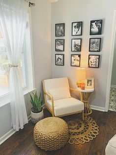 a living room with pictures on the wall and a chair next to a small table