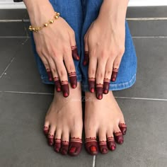 a woman's feet with red nail polish and gold bracelet on her left foot