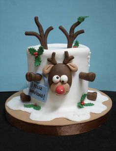 a christmas cake with reindeer decorations on it's face and nose, sitting on top of a table