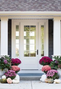 two planters filled with flowers sitting in front of a door